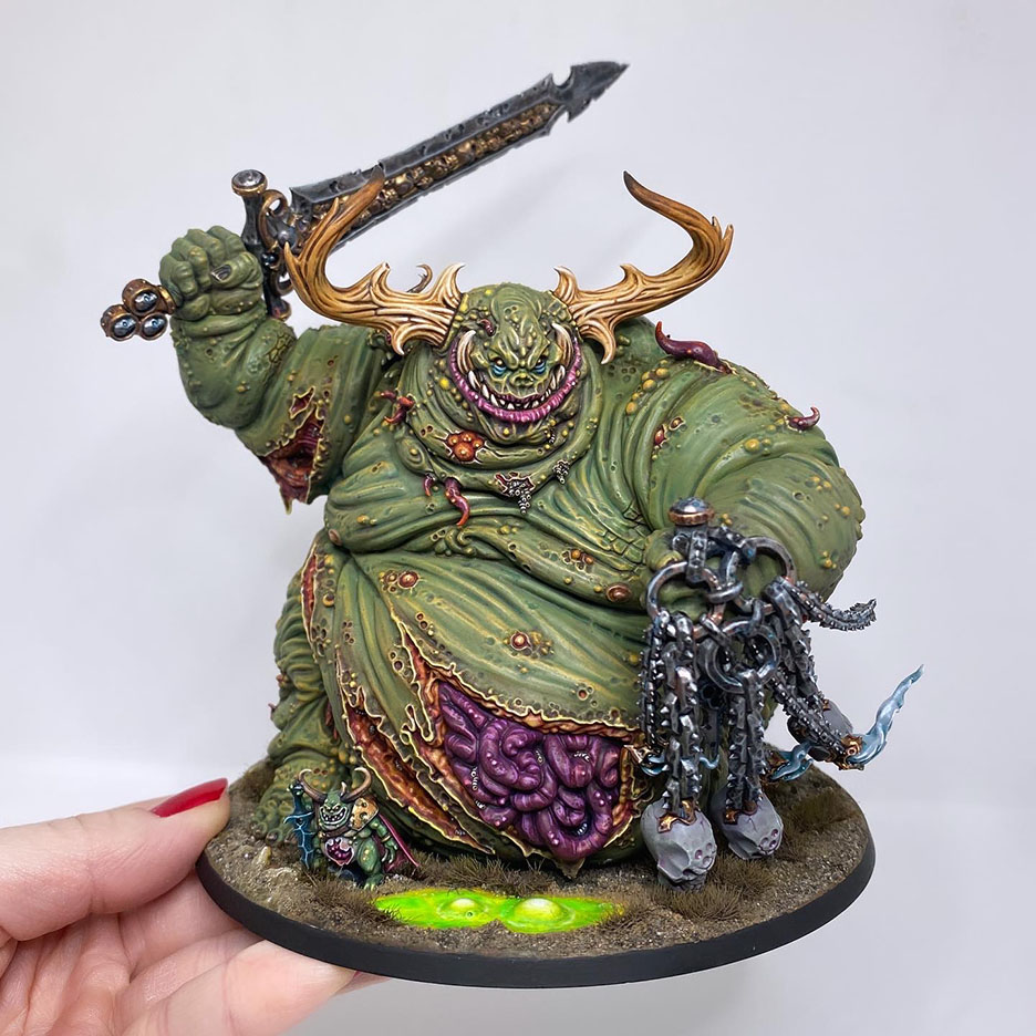 The Great Unclean One / Rotigus is built and painted. There are 3 different distinct builds for AOS and 40K. I have magnetized all the parts of the Great Unclean One and Rotigus. We now have 3 different heads, 3 left arms, 3 right arms and 2 stomach inserts. This way, you can play any variant you want. This is a truly vile model (in the most positive sense of the word!) – it celebrates its corpulence, with rotten, torn flesh slipping aside on its enormous gut to reveal winding intestines within. What an awesome model. Those details are perfectly gruesome. Warhammer - Age of Sigmar and 40K Maggotkin of Nurgle. 👉 Do you want me to build or paint for you? Feel free to contact me. I am excited to hear from you! Height: 13 cm (without weapons) Patching: Green Stuff by citadel_paints Base: custom made with clay Paints: vallejocolors Painted to level: Display Publisher: warhammerofficial Painted by: Debbie Maasdam