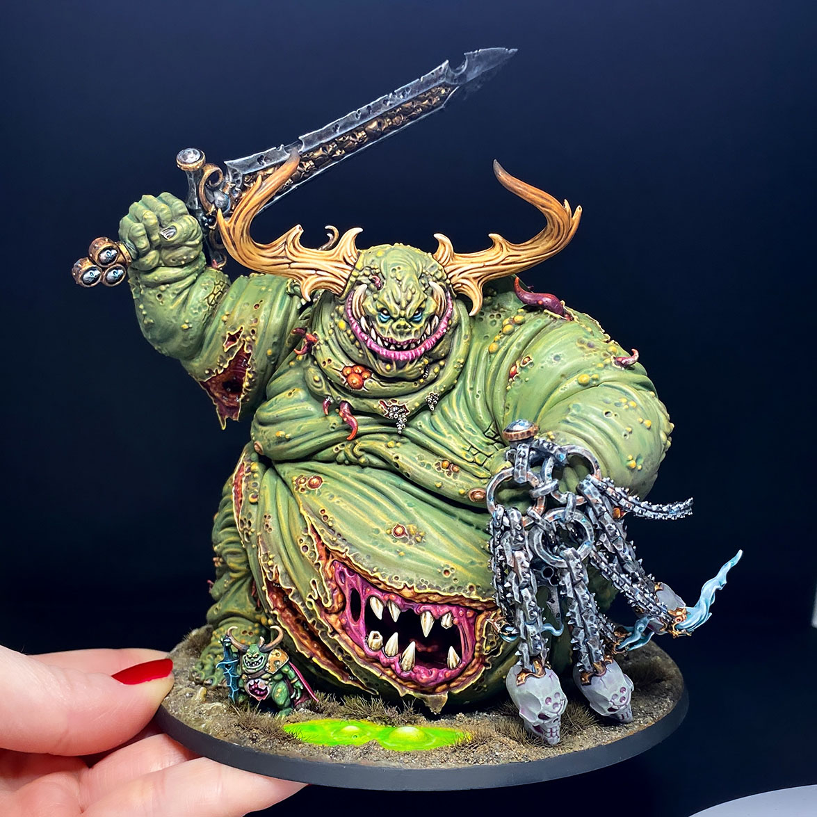 The Great Unclean One / Rotigus is built and painted. There are 3 different distinct builds for AOS and 40K. I have magnetized all the parts of the Great Unclean One and Rotigus. We now have 3 different heads, 3 left arms, 3 right arms and 2 stomach inserts. This way, you can play any variant you want. This is a truly vile model (in the most positive sense of the word!) – it celebrates its corpulence, with rotten, torn flesh slipping aside on its enormous gut to reveal winding intestines within. What an awesome model. Those details are perfectly gruesome. Warhammer - Age of Sigmar and 40K Maggotkin of Nurgle. 👉 Do you want me to build or paint for you? Feel free to contact me. I am excited to hear from you! Height: 13 cm (without weapons) Patching: Green Stuff by citadel_paints Base: custom made with clay Paints: vallejocolors Painted to level: Display Publisher: warhammerofficial Painted by: Debbie Maasdam