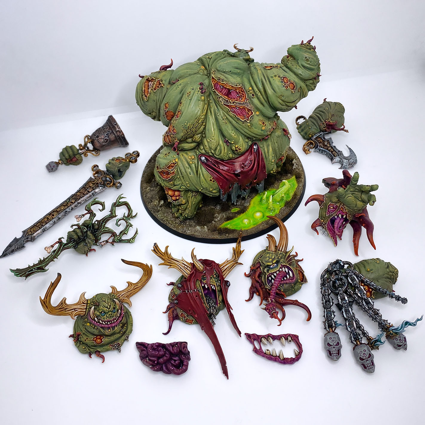 The Great Unclean One / Rotigus is built and painted. There are 3 different distinct builds for AOS and 40K. I have magnetized all the parts of the Great Unclean One and Rotigus. We now have 3 different heads, 3 left arms, 3 right arms and 2 stomach inserts. This way, you can play any variant you want. This is a truly vile model (in the most positive sense of the word!) – it celebrates its corpulence, with rotten, torn flesh slipping aside on its enormous gut to reveal winding intestines within. What an awesome model. Those details are perfectly gruesome. Warhammer - Age of Sigmar and 40K Maggotkin of Nurgle. 👉 Do you want me to build or paint for you? Feel free to contact me. I am excited to hear from you! Height: 13 cm (without weapons) Patching: Green Stuff by citadel_paints Base: custom made with clay Paints: vallejocolors Painted to level: Display Publisher: warhammerofficial Painted by: Debbie Maasdam