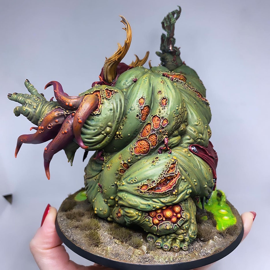 The Great Unclean One (variant #1!) is done! There are 3 different distinct builds for AOS and 40K. I have magnetized all the parts of the Great Unclean One and Rotigus. We now have 3 different heads, 3 left arms, 3 right arms and 2 stomach inserts. This way, you can play any variant you want. This is a truly vile model (in the most positive sense of the word!) – it celebrates its corpulence, with rotten, torn flesh slipping aside on its enormous gut to reveal winding intestines within. What an awesome model. Those details are perfectly gruesome. Warhammer - Age of Sigmar and 40K Maggotkin of Nurgle. 👉 Do you want me to build or paint for you? Feel free to contact me. I am excited to hear from you! Height: 13 cm (without weapons) Patching: Green Stuff by citadel_paints Base: custom made with clay Paints: vallejocolors Painted to level: Display Publisher: warhammerofficial Painted by: Debbie Maasdam